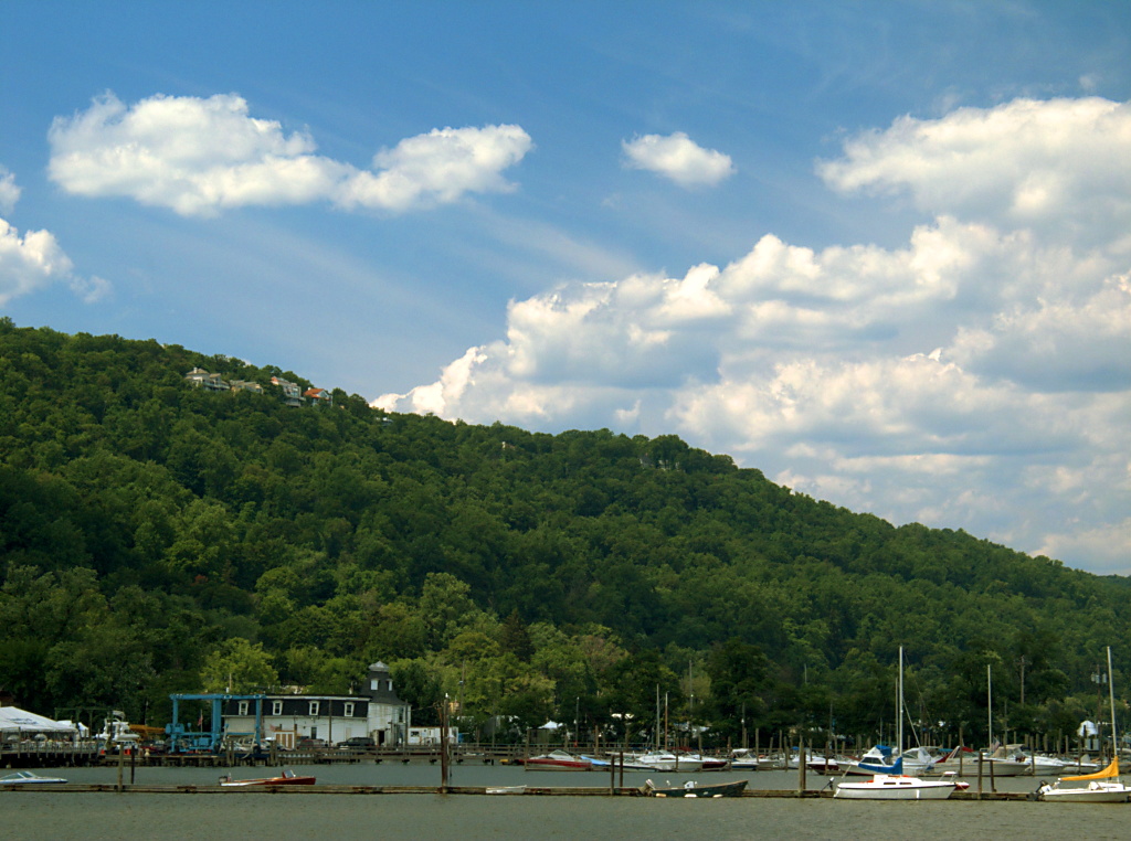 Boats at Piermont Marina beneath a green hillside and summer sky