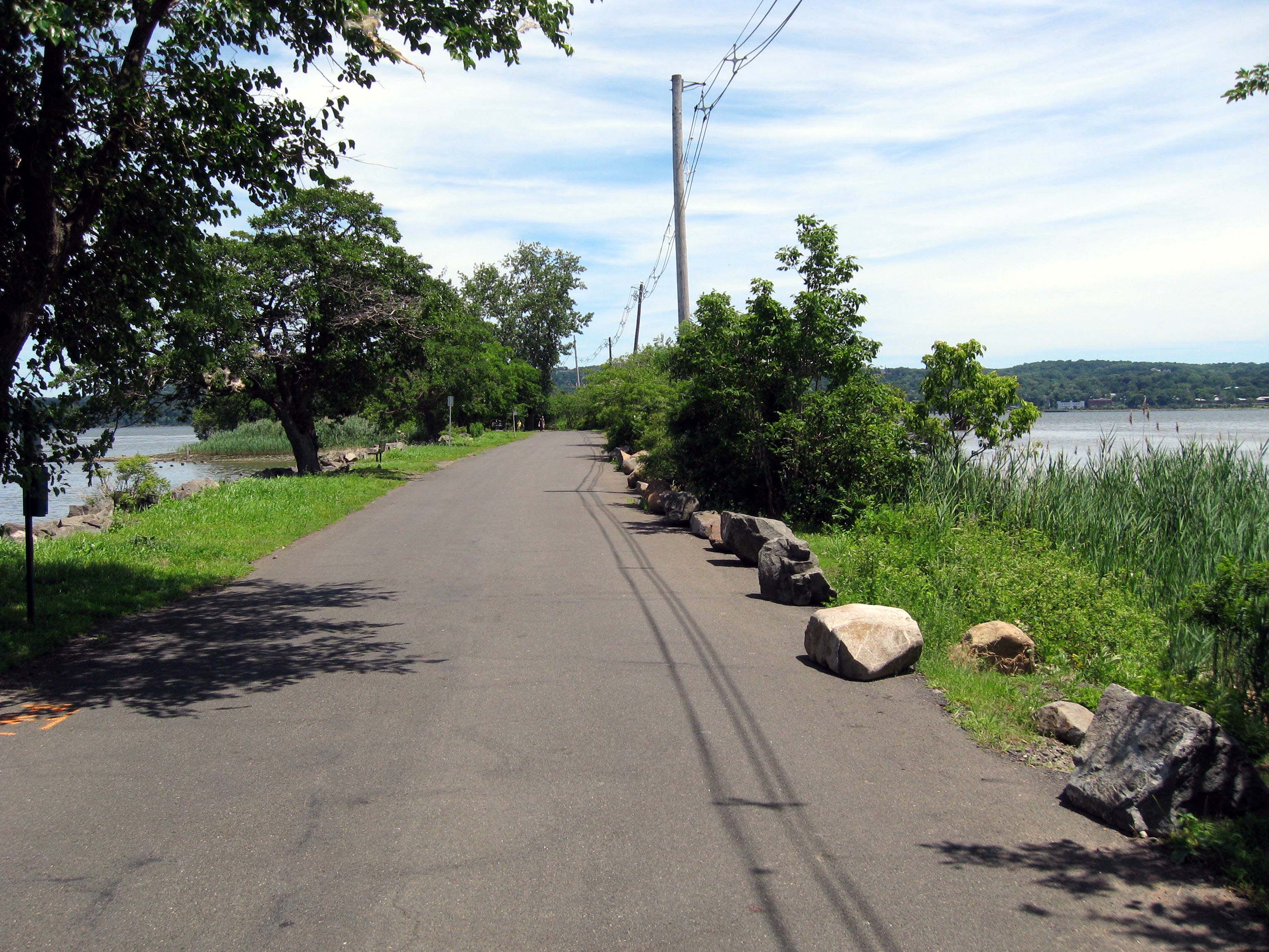 Paved Piermont Pier path beside Hudson River marsh grasses